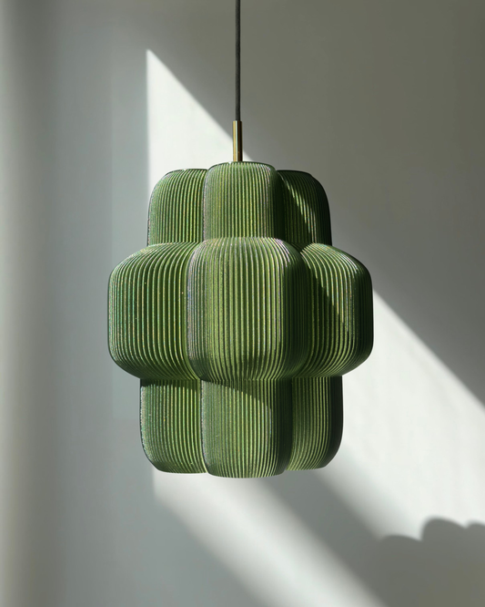 Petulia flower design pendant light turned on casting warm light and shadows. Green translucent 